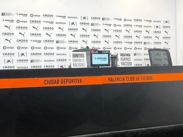 En la mesa donde comparece Baraja hay dos carteles con los lemas: «Juntos contra el racismo» y su traducción al inglés «Together against racism».