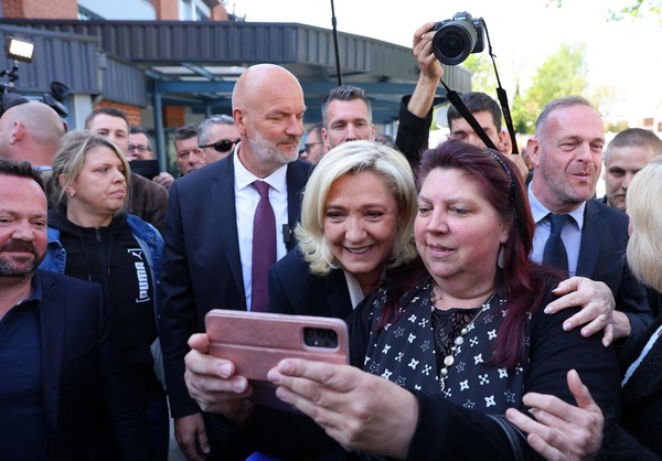 La candidata de Agrupación Nacional, Marine Le Pen, arropada por sus seguidores en la jornada electoral. AFP