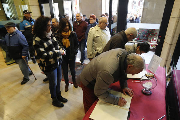 Los gijoneses dejan sus condolencias en los libros habilitados para ello en el hall del Consistorio gijonés. FOTO: Jorge Peteiro