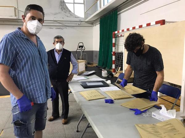 Los componentes de las mesas electorales comienzan a abandonar los colegios tras una larga jornada. En la imagen el presidente de una de las mesas de Lezo, de fondo el alcalde Jesús María Martiarena y el juez de paz recibiendo las actas. / Ainhoa Iglesias