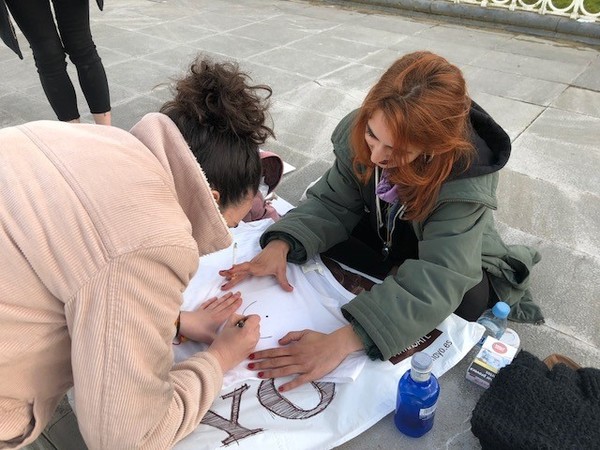Un grupo de amigas prepara pancartas y camisetas reivindicativas en el paseo de Ondarreta