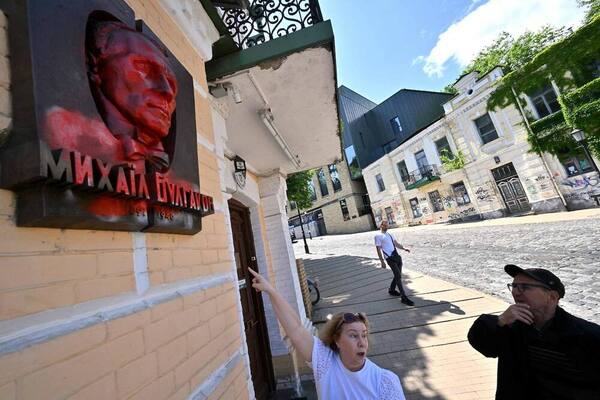 La directora del museo, Lyudmyla Gubianuri, muestra la placa que representa al ruso Mikhail Bulgakov, el autor de «El maestro y Margarita», cubierta con pintura roja como señal de protesta, en Kiev. Foto: AFP