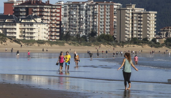Gente paseando por la playa en Laredo.