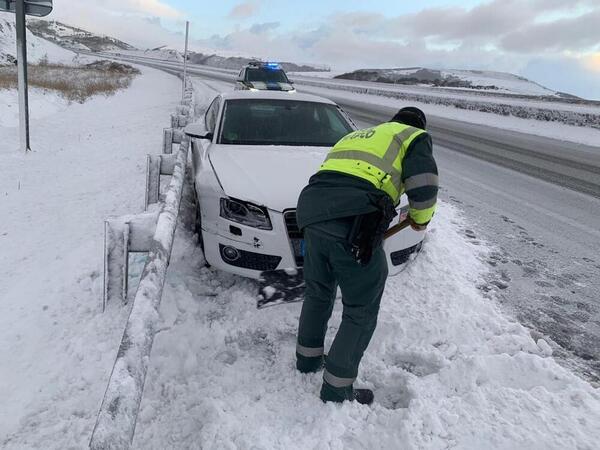Efectivos de la Guardia Civl auxilian a un conductor con problemas para circular con nieve.