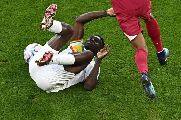 El delantero de Senegal, Ismaila Sarr y el defensa de Qatar, Homam Ahmed luchan por el balón.