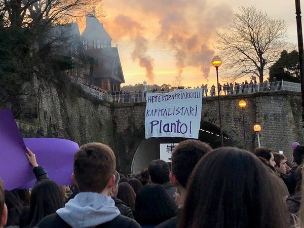 Las manifestantes despliegan una pancarta desde los jardines del Palacio de Miramar en la que se puede leer: “Heteropatriarkado kapitalistari planto!”. / Ainhoa Múgica